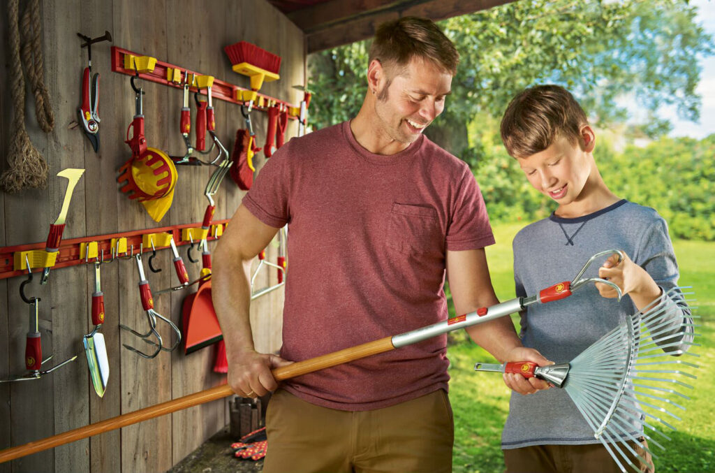 Un père montre à son fils comment changer facilement les accessoires du système multi-Star(R) de WOLF-Garten. 